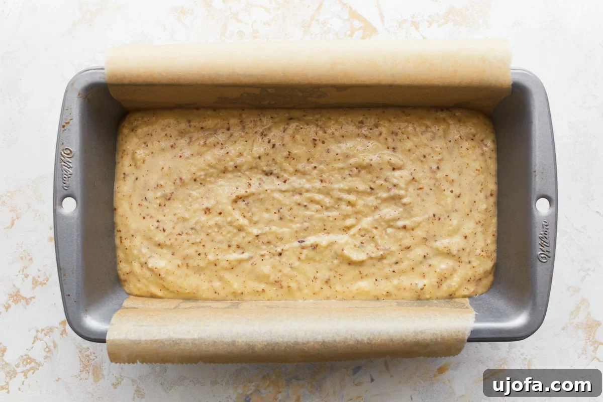 Grain-Free Almond Loaf 7 The smooth, pale almond flour bread dough has been carefully poured into a parchment-lined loaf pan, prepped and ready for baking, promising a delicious and wholesome bread.