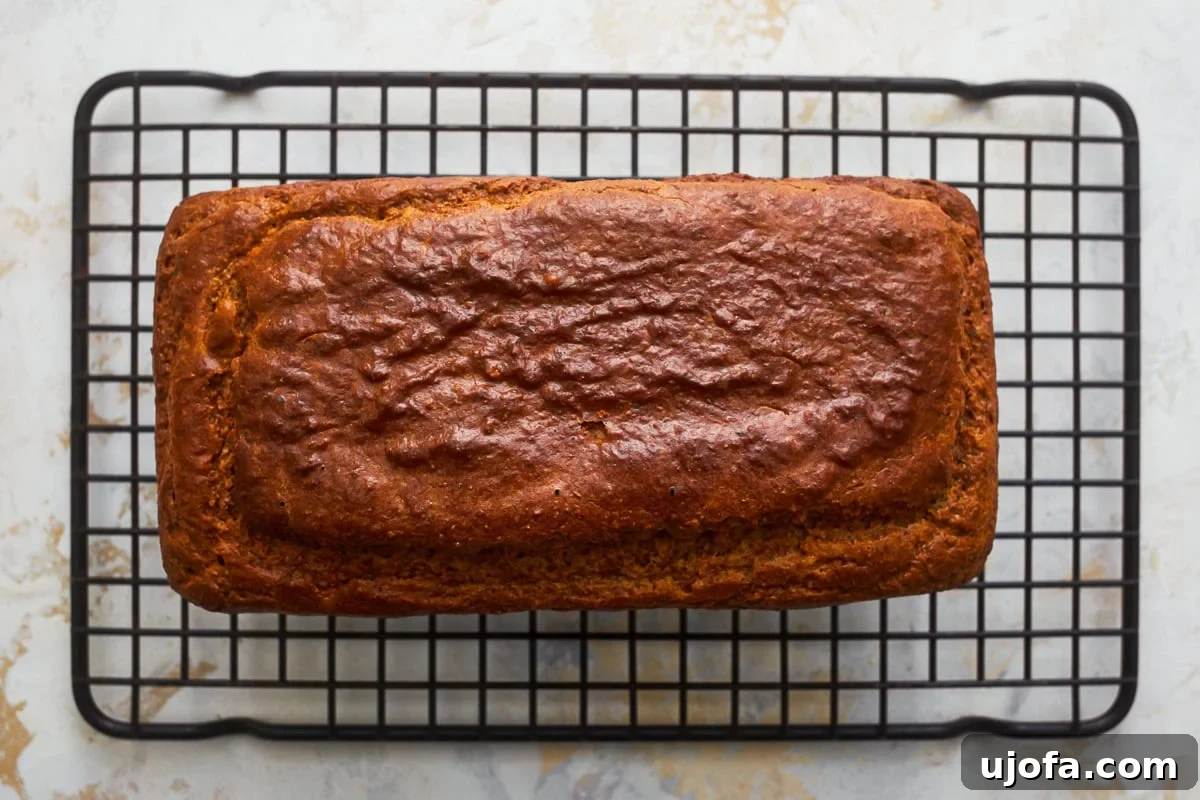 Grain-Free Almond Loaf 8 An appetizing overhead view of a freshly baked loaf of almond flour bread, golden brown and cooling on a wire rack, its fragrant steam hinting at a perfectly moist interior.