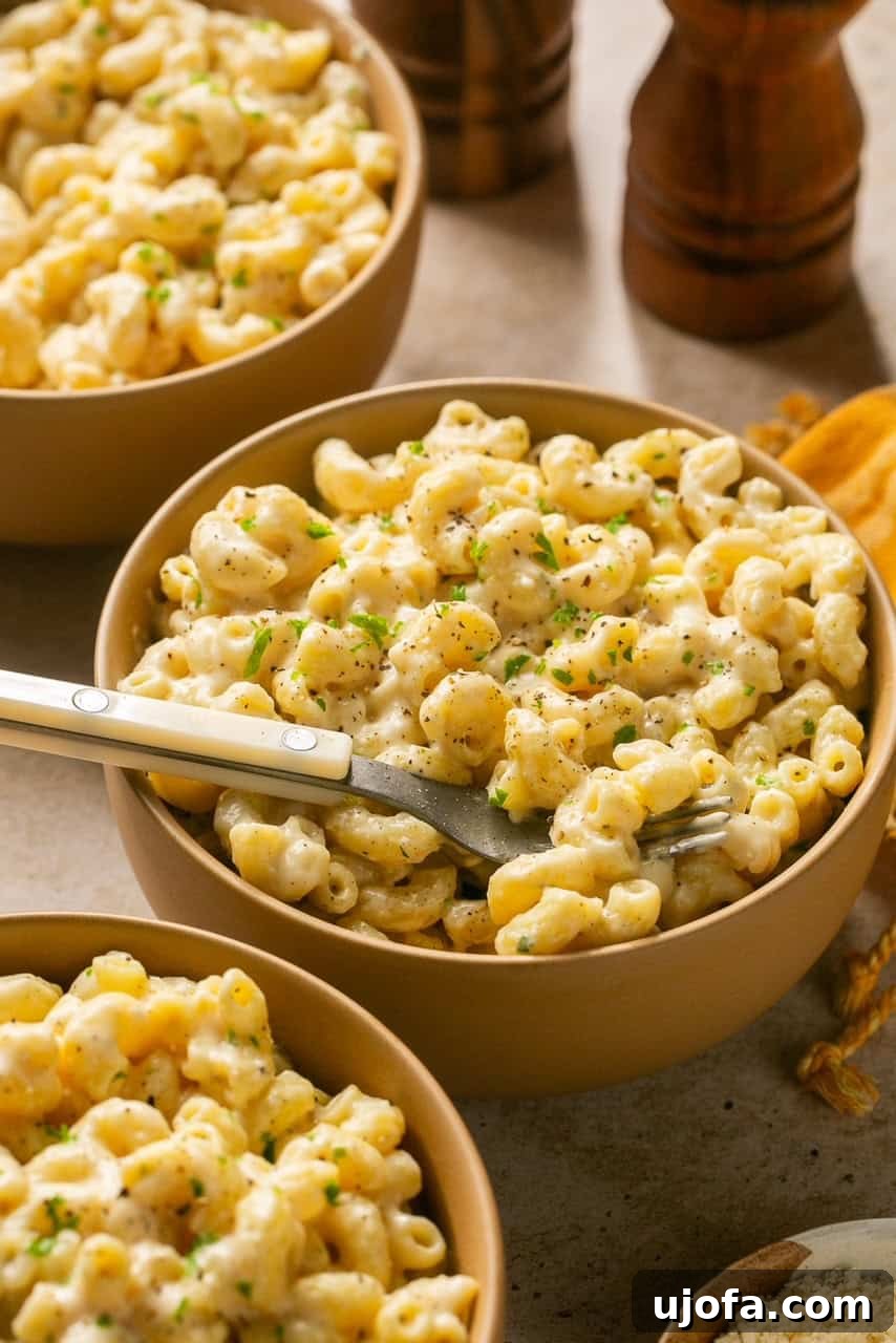 A bowl of creamy high protein cottage cheese mac and cheese with a spoon, ready to be enjoyed.