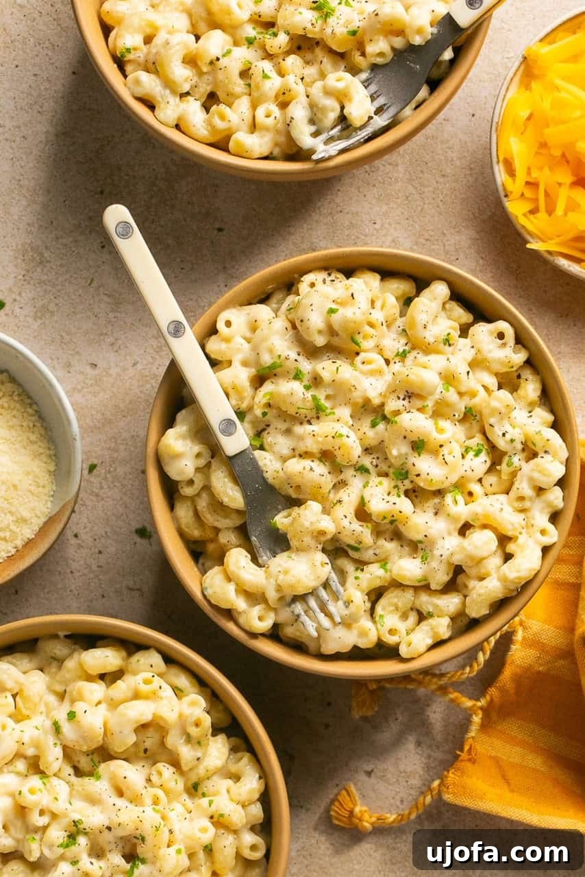 A serving of protein mac and cheese in a bowl with a fork, ready to be eaten.
