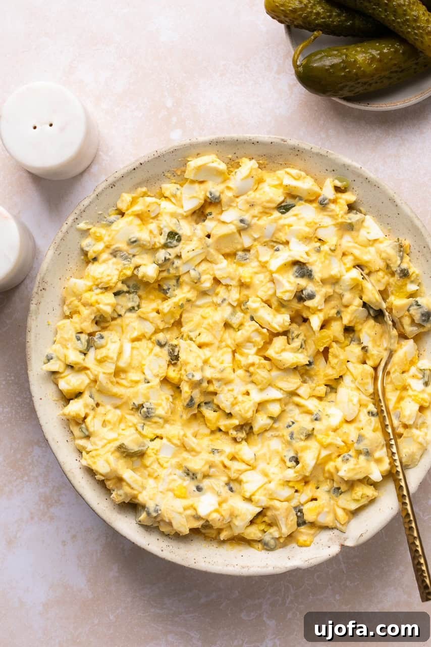 All the ingredients for the dill pickle egg salad are fully mixed together in a bowl, showcasing the creamy texture and pickle bits.