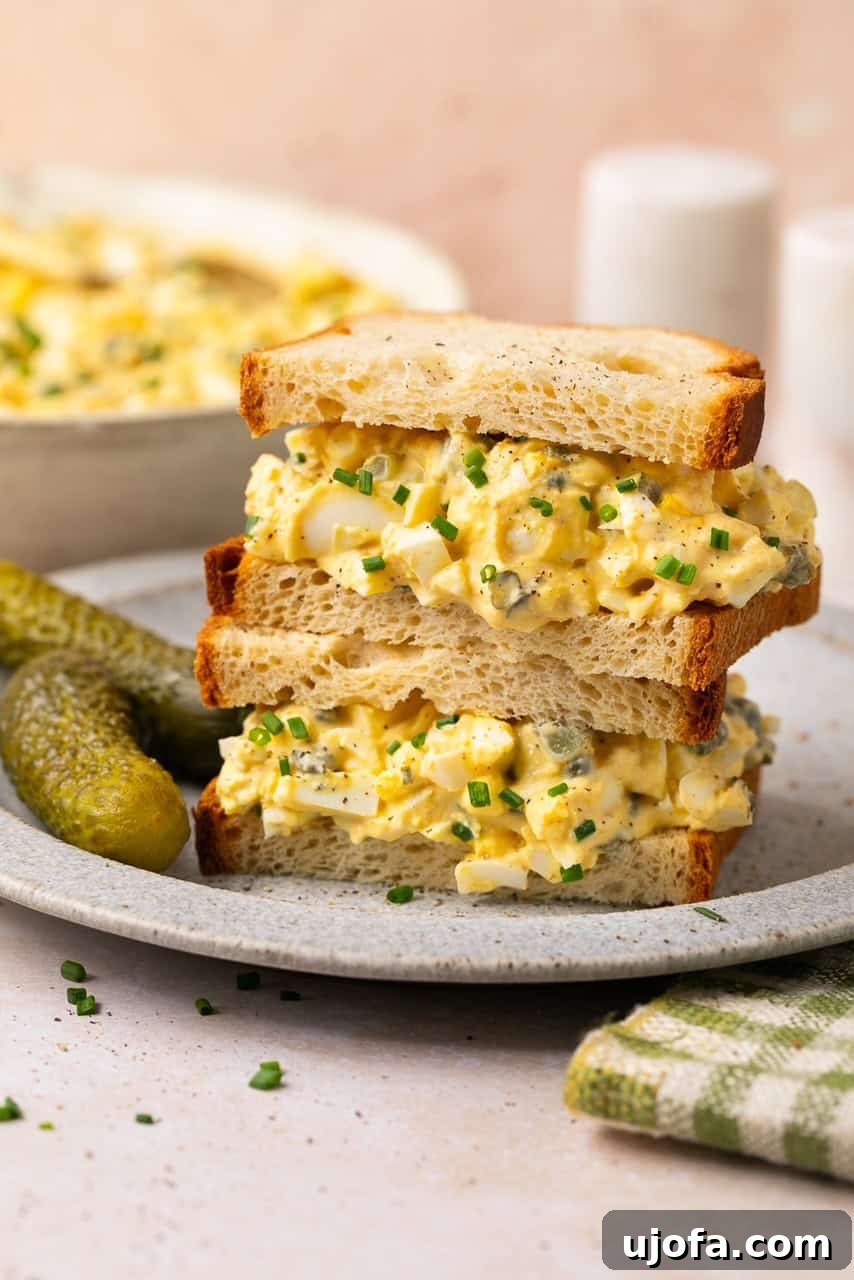 Stacked egg salad sandwiches made with gluten-free bread, showcasing the hearty and delicious filling.