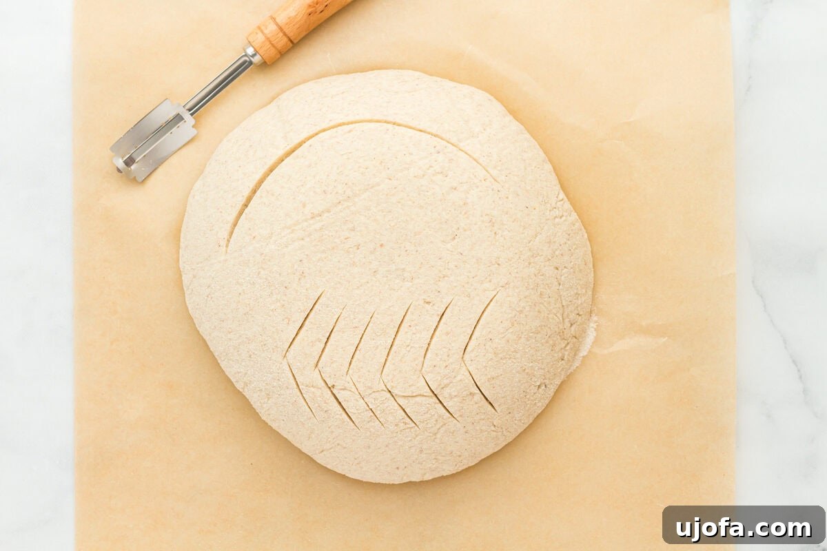 The Art of Gluten-Free Sourdough 13 Gluten-free sourdough bread dough expertly scored with a lame, revealing a decorative pattern before baking.