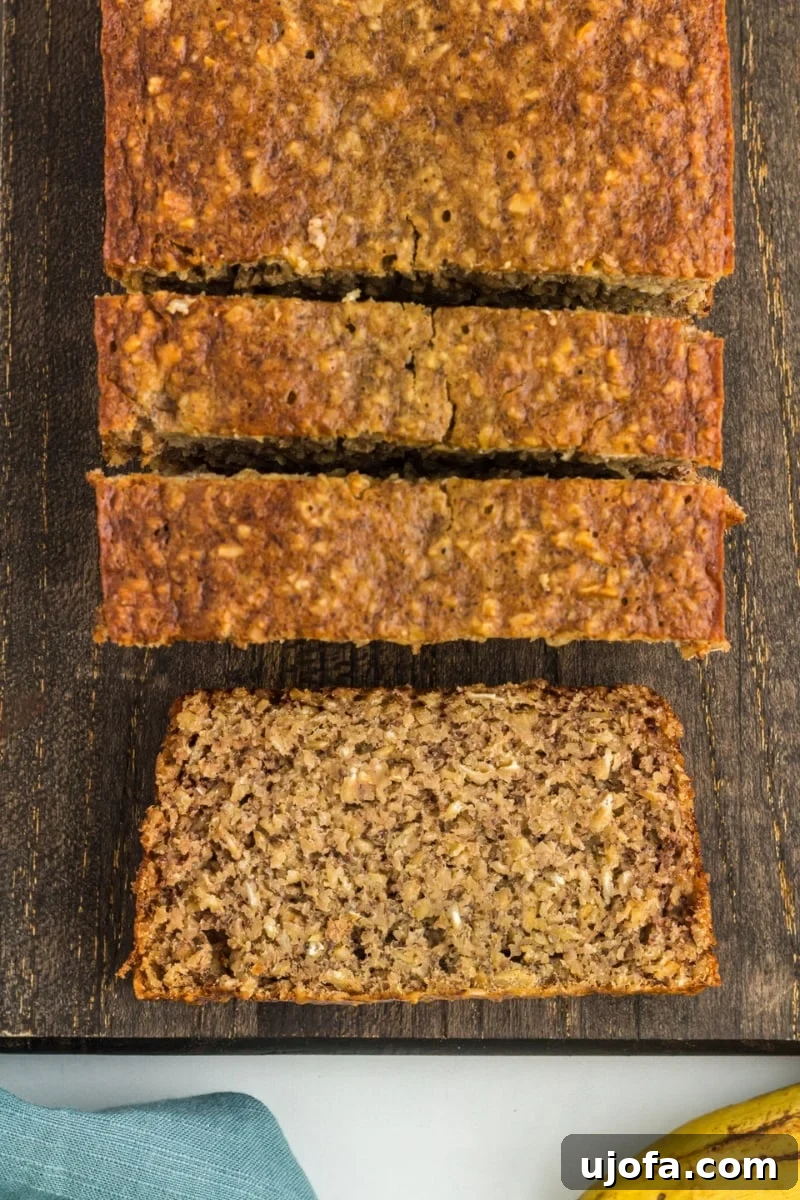 Wholesome Banana Bliss 2 Slices of moist, golden-brown flourless banana bread on a dark brown cutting board, garnished with a few whole oats.