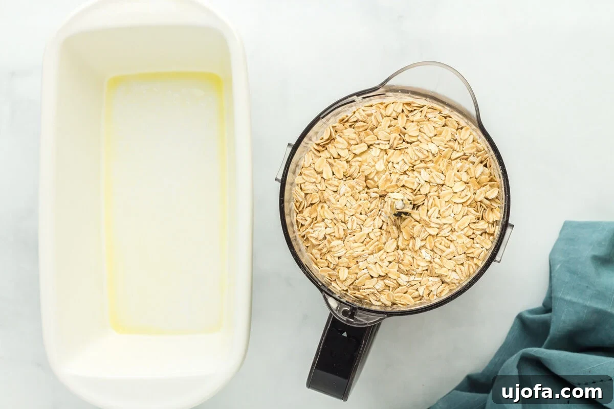 Wholesome Banana Bliss 7 Old-fashioned oats in a food processor next to a greased baking dish, ready for blending.
