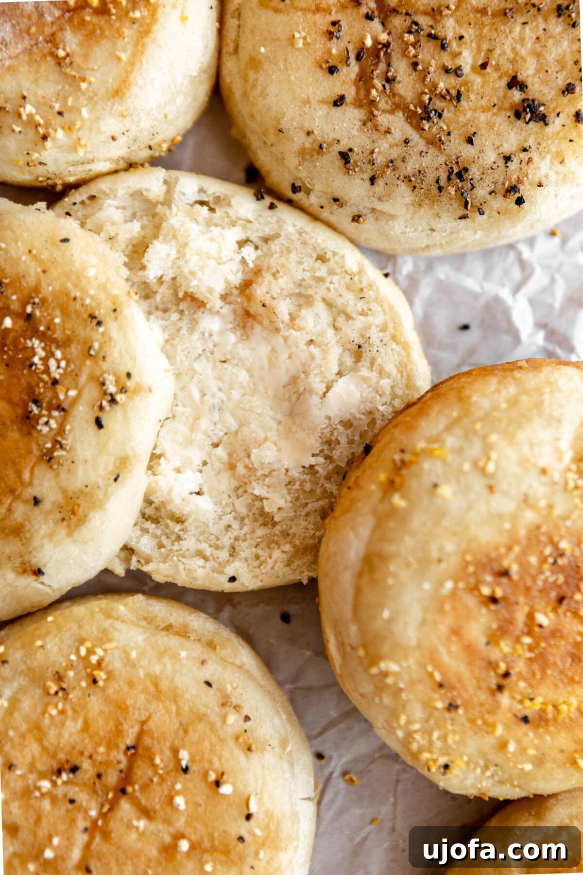 Gluten-free English muffin split open and spread with melted butter, ready to be enjoyed.