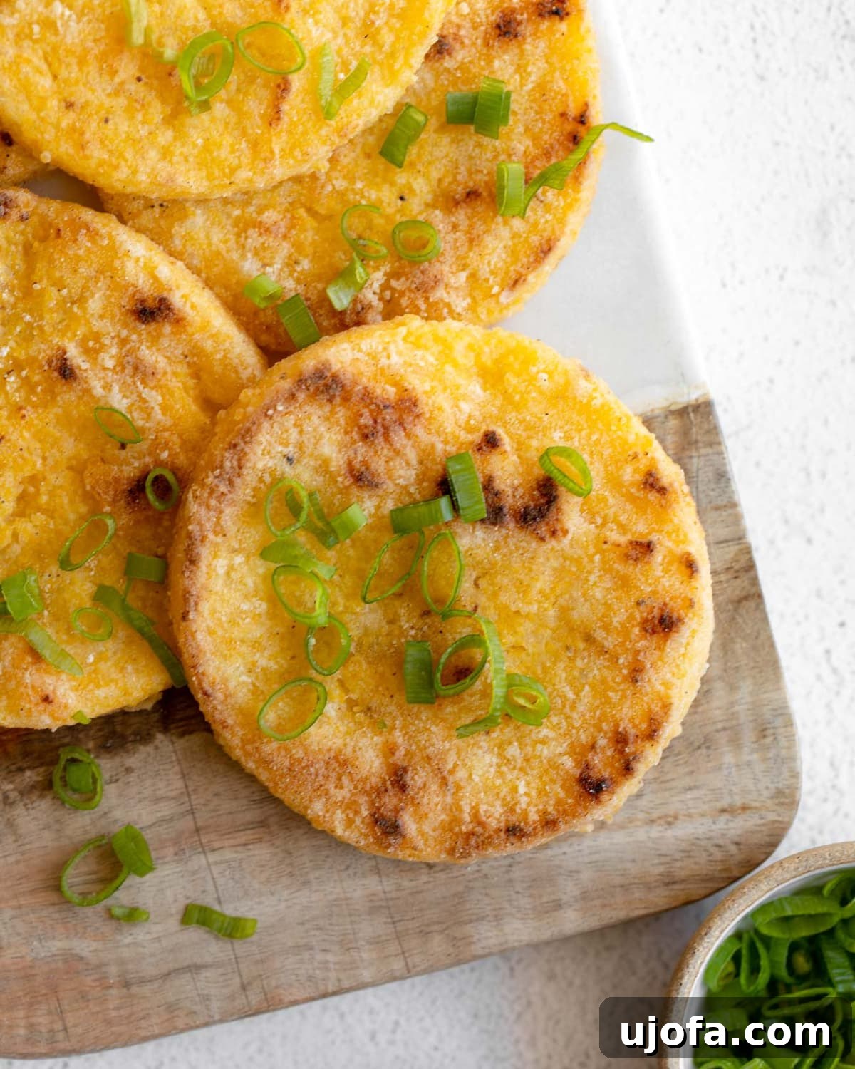 Golden Fried Grits 2 Crispy homemade grit cakes on a rustic cutting board, ready to be served.