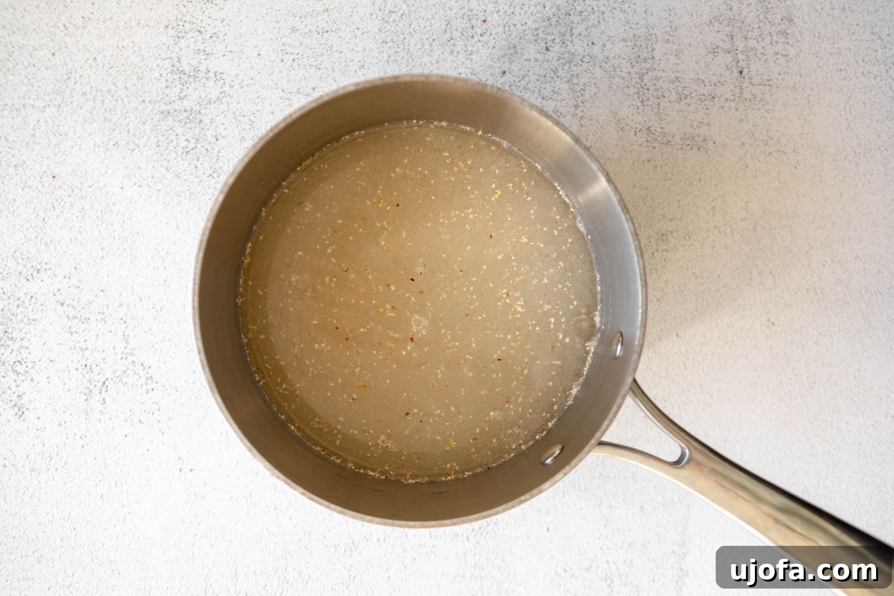 Golden Fried Grits 5 Water and uncooked grits combined in a saucepan, ready for cooking.