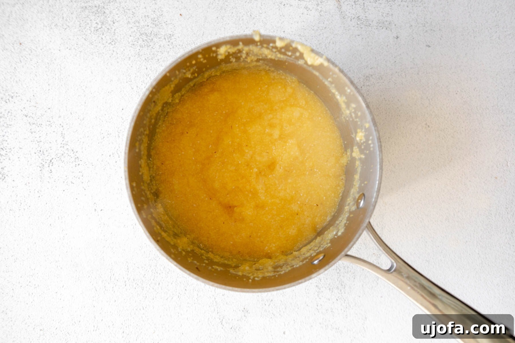 Golden Fried Grits 6 Cooked grits, thick and creamy, resting in a saucepan after simmering.