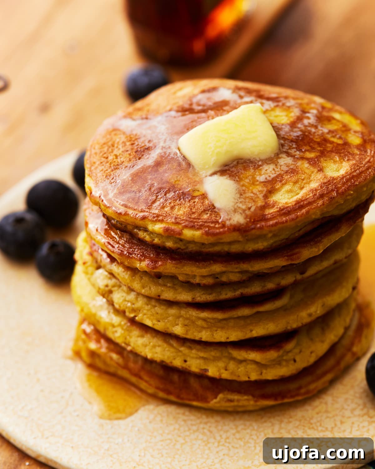 Stacked coconut flour pancakes topped with butter and fresh blueberries, ready to be served for breakfast.