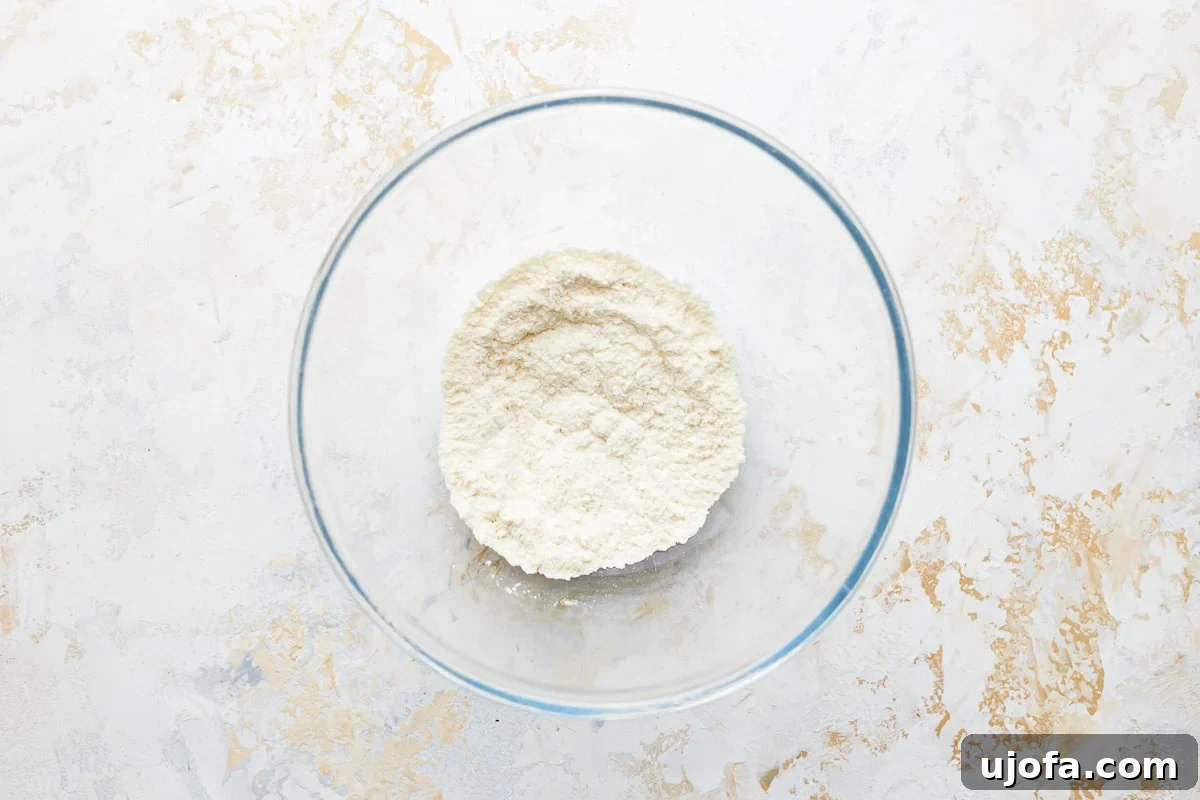 Coconut flour measured in a glass bowl, ready for mixing with other dry ingredients.