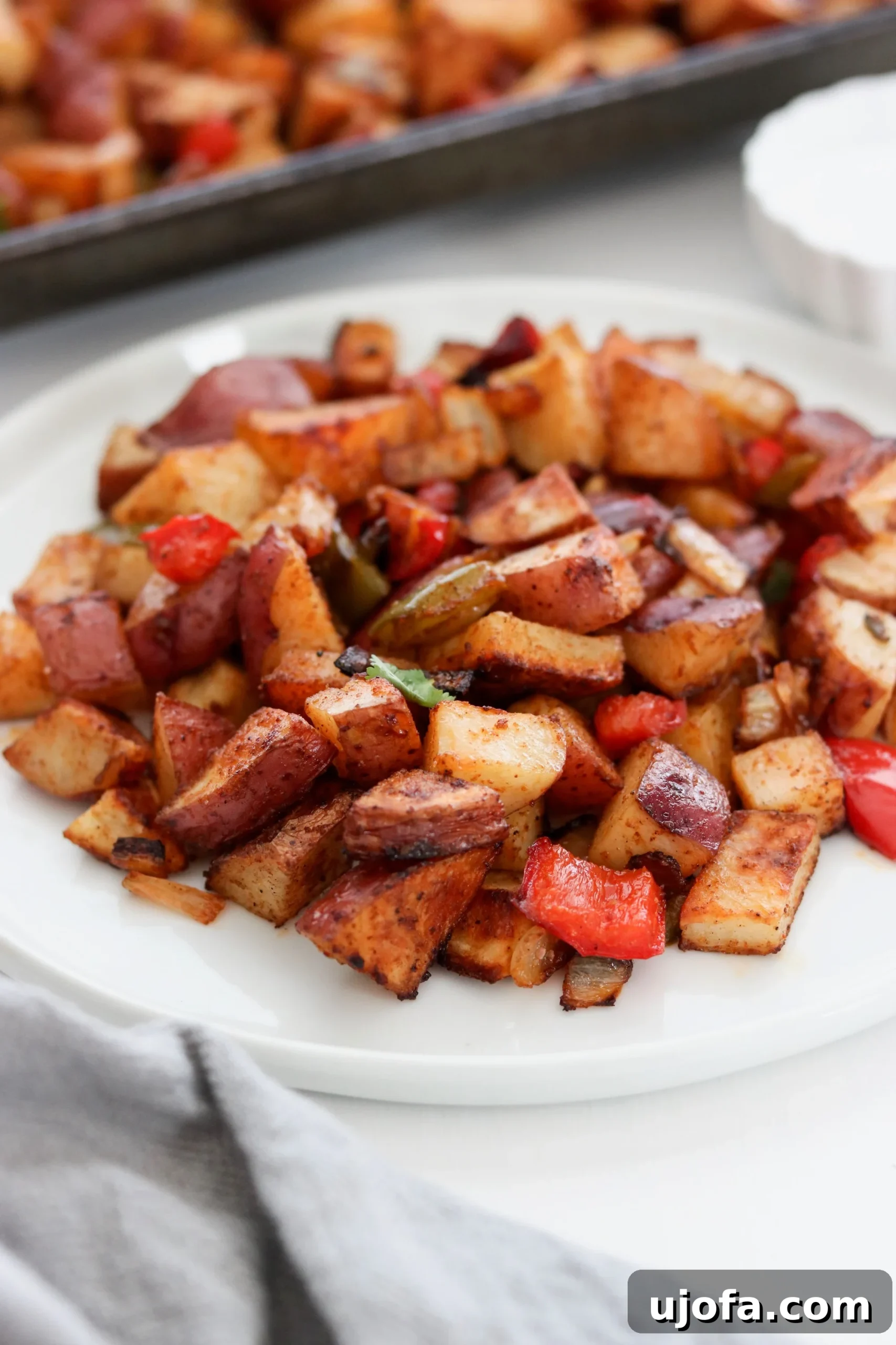 Overhead shot of Sheet Pan Southwest Breakfast Potatoes with a spoon, highlighting their crispiness