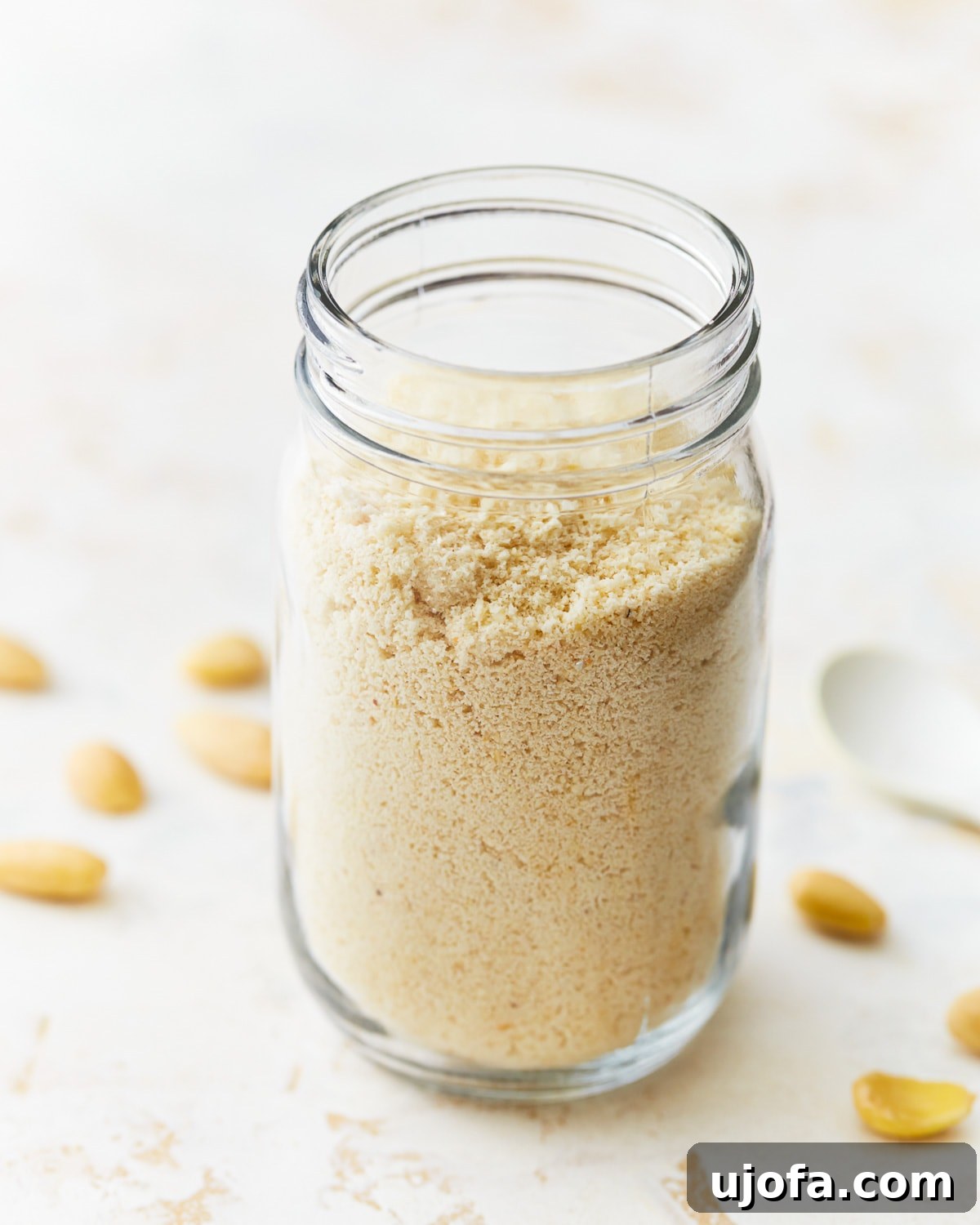 Homemade almond flour showcased in a mason jar without a lid, emphasizing its texture.
