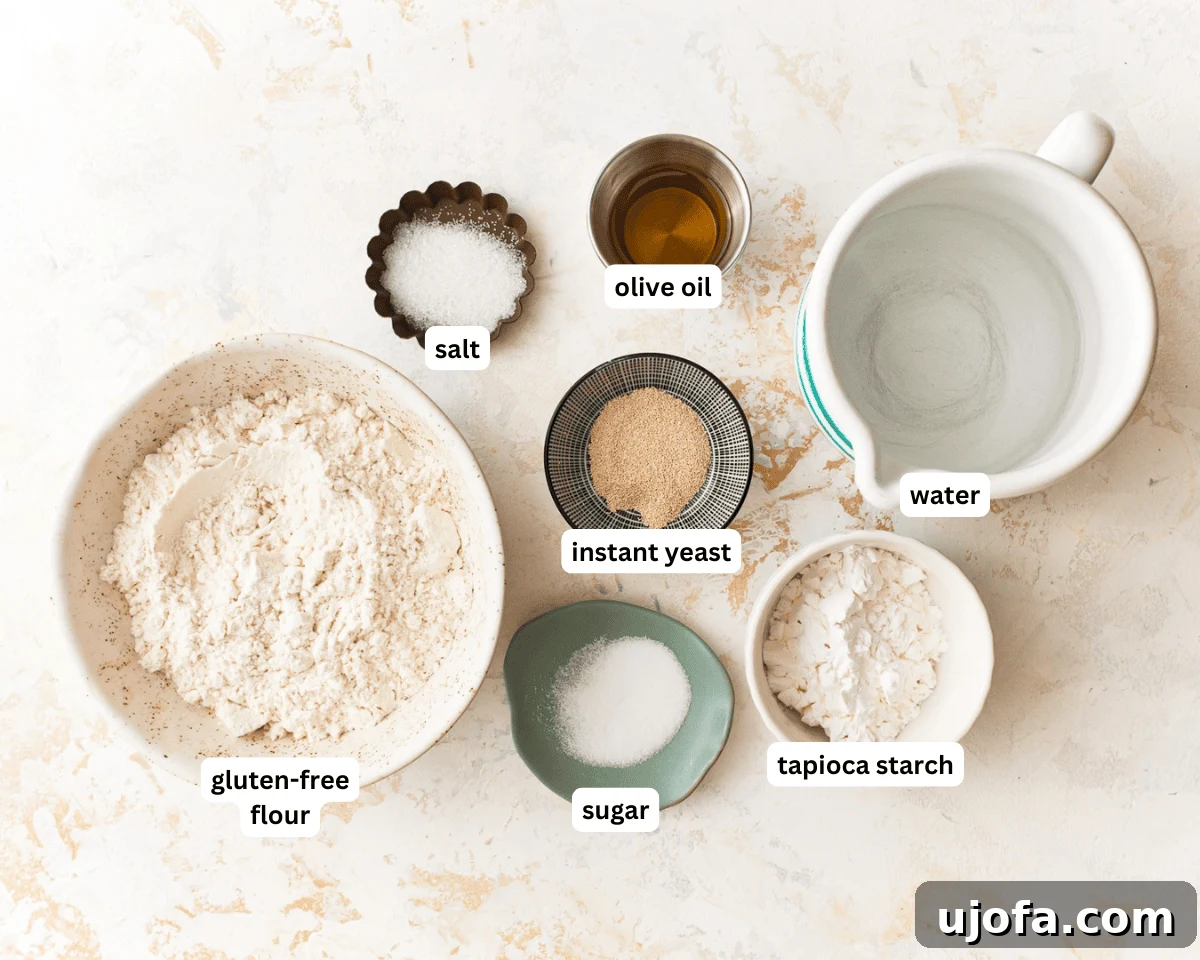 A flat lay of all gluten-free pizza dough ingredients including flour, yeast, water, olive oil, and apple cider vinegar.