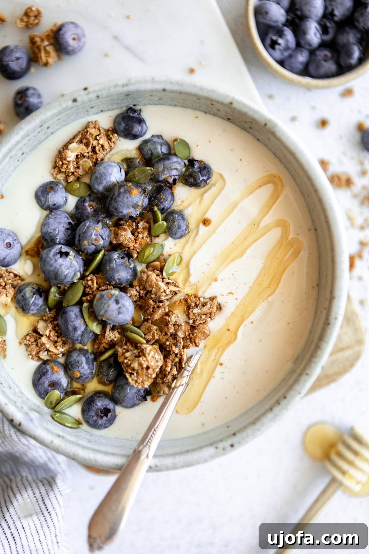 A bowl of homemade dairy-free coconut yogurt topped with fresh granola and vibrant fruit, ready to be enjoyed.
