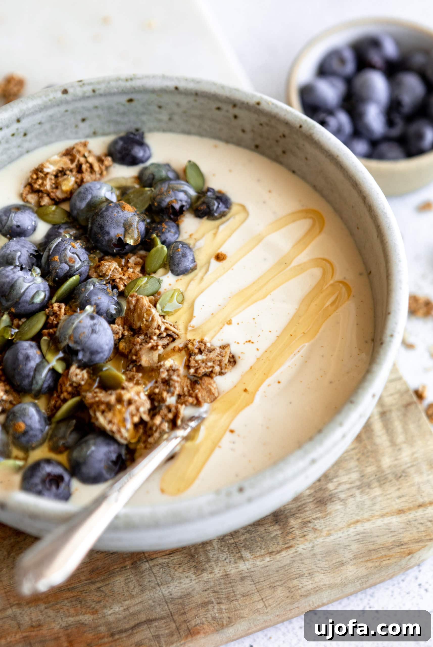 A beautifully presented bowl of dairy-free coconut yogurt adorned with fresh berries and granola.