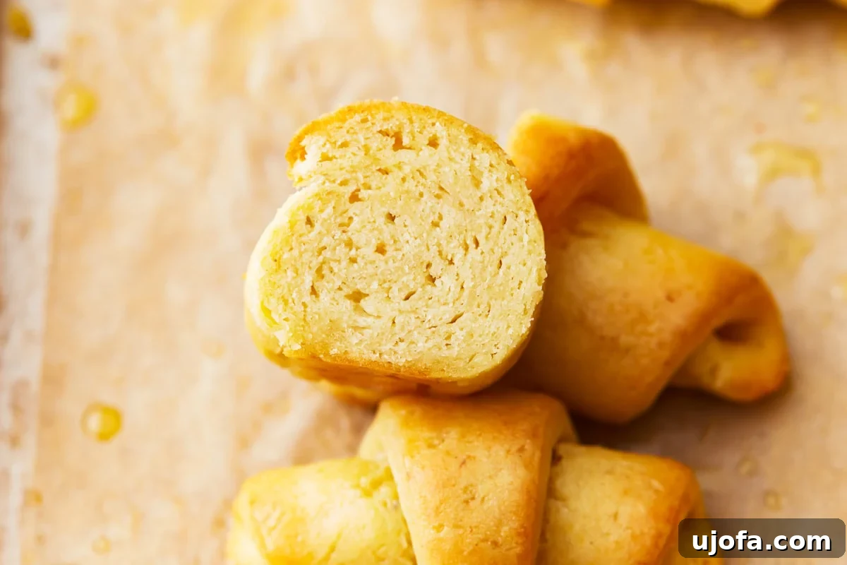 Buttery Gluten-Free Crescent Rolls 11 a gluten-free crescent roll cut in half, revealing its light and airy interior crumb.