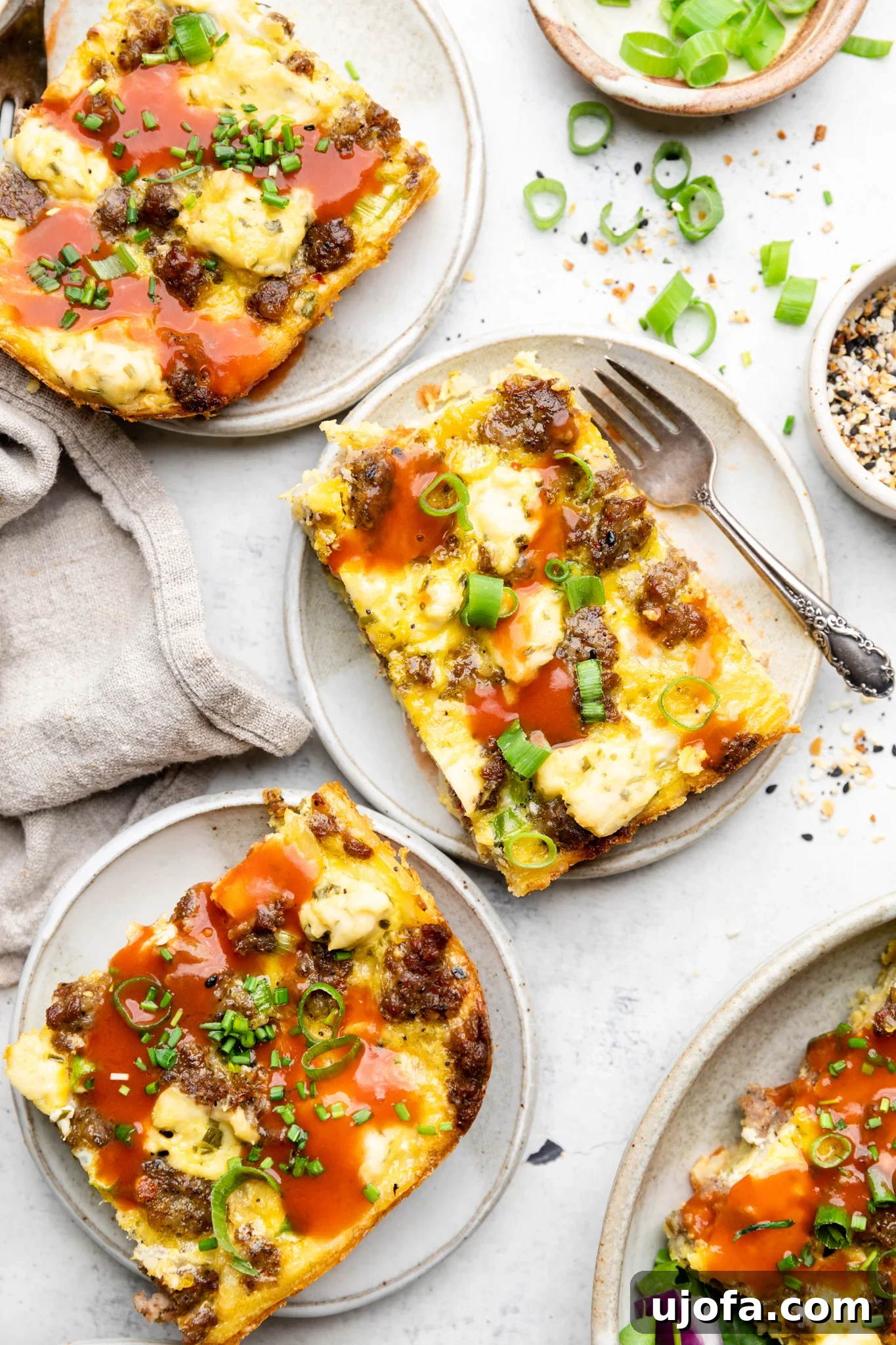 Wholesome Breakfast Casserole Gluten Free Dairy Free 7 Three slices of sausage hash brown breakfast casserole served on plates with hot sauce and fresh green onions.