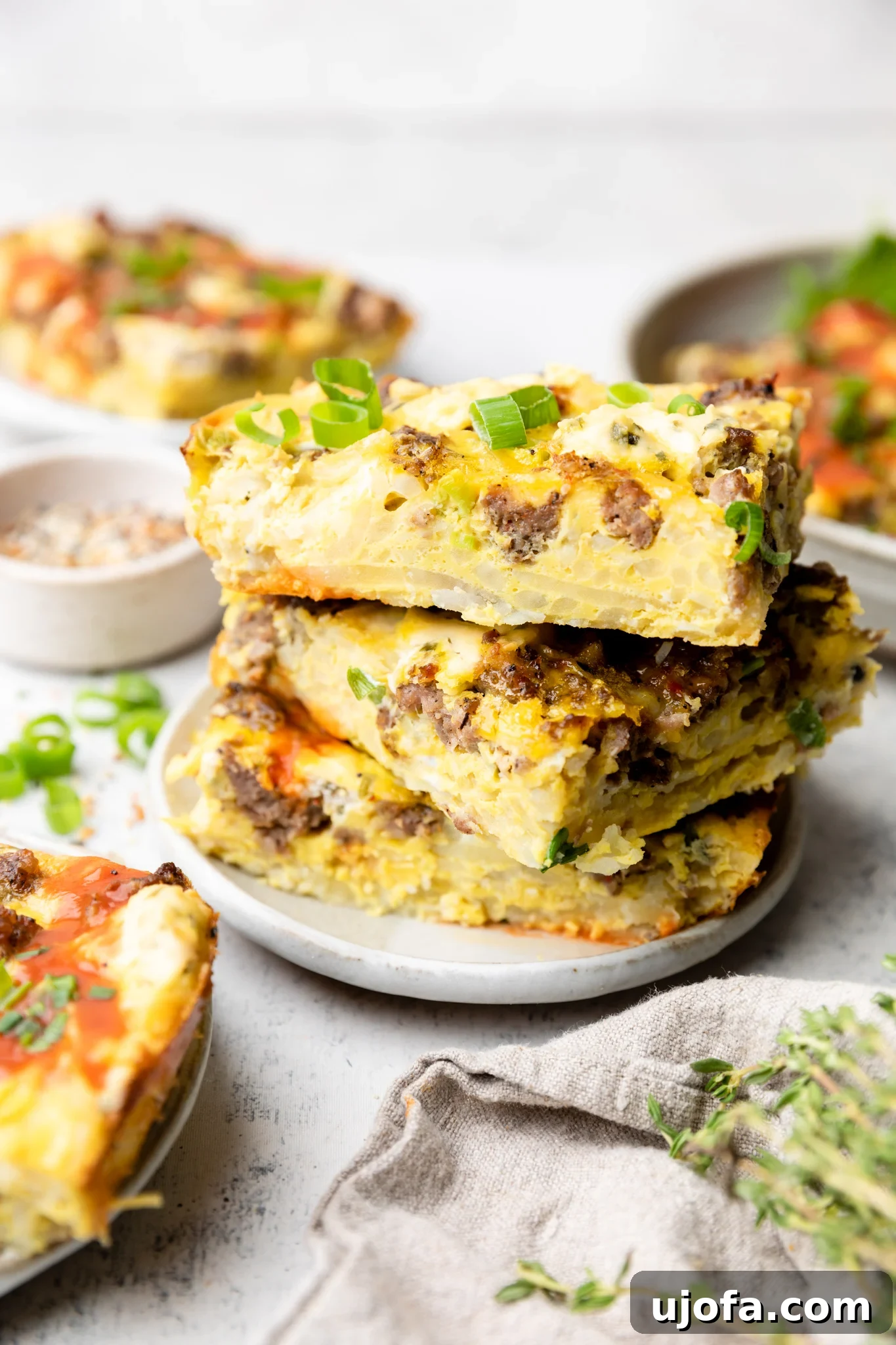 Wholesome Breakfast Casserole Gluten Free Dairy Free 8 Square slices of sausage hash brown casserole stacked neatly on a plate, ready to serve.