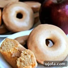 A plate of freshly baked gluten-free apple cinnamon donuts with maple glaze.