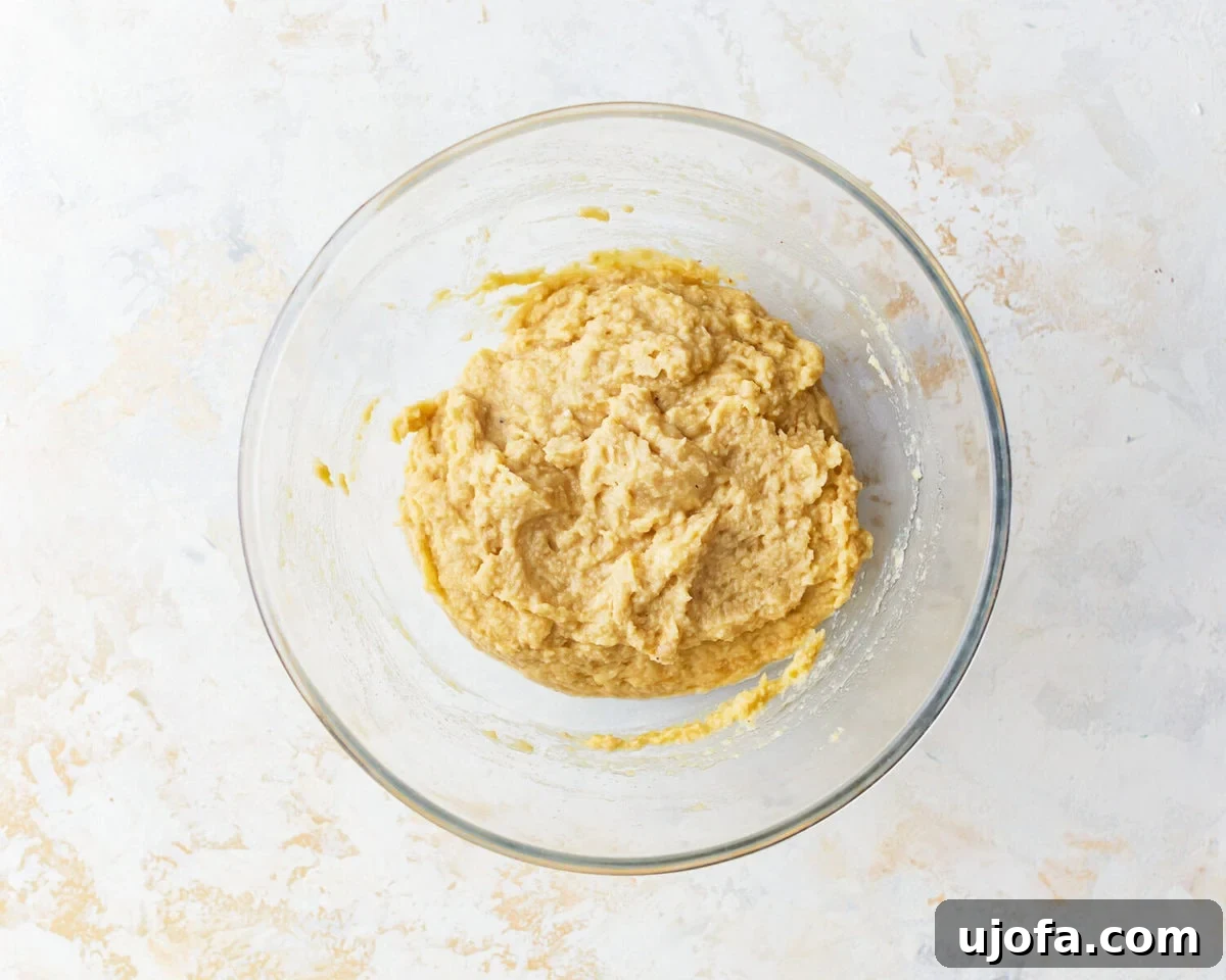 Almond flour banana muffin dough in a glass bowl, showing the consistency before baking.