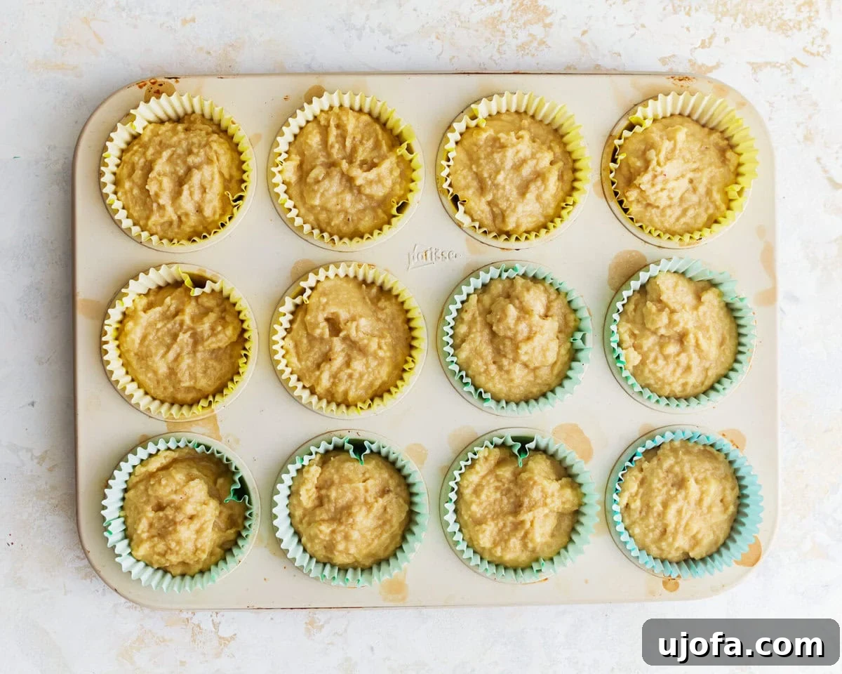 Overhead view of almond flour banana muffin batter evenly portioned into a muffin tin.