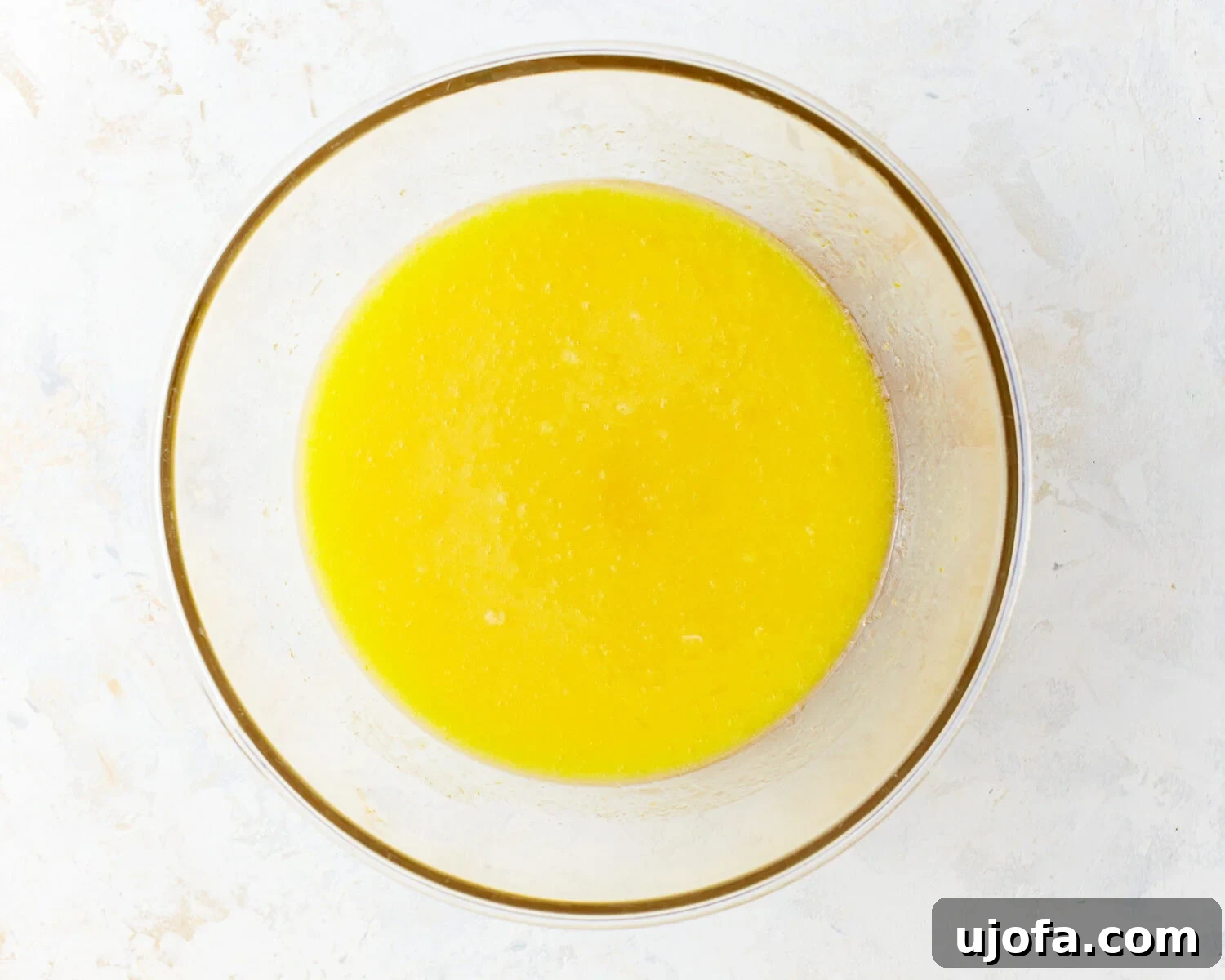 Mixed Wet Ingredients Wet ingredients for gluten-free vanilla cake batter in a glass mixing bowl.