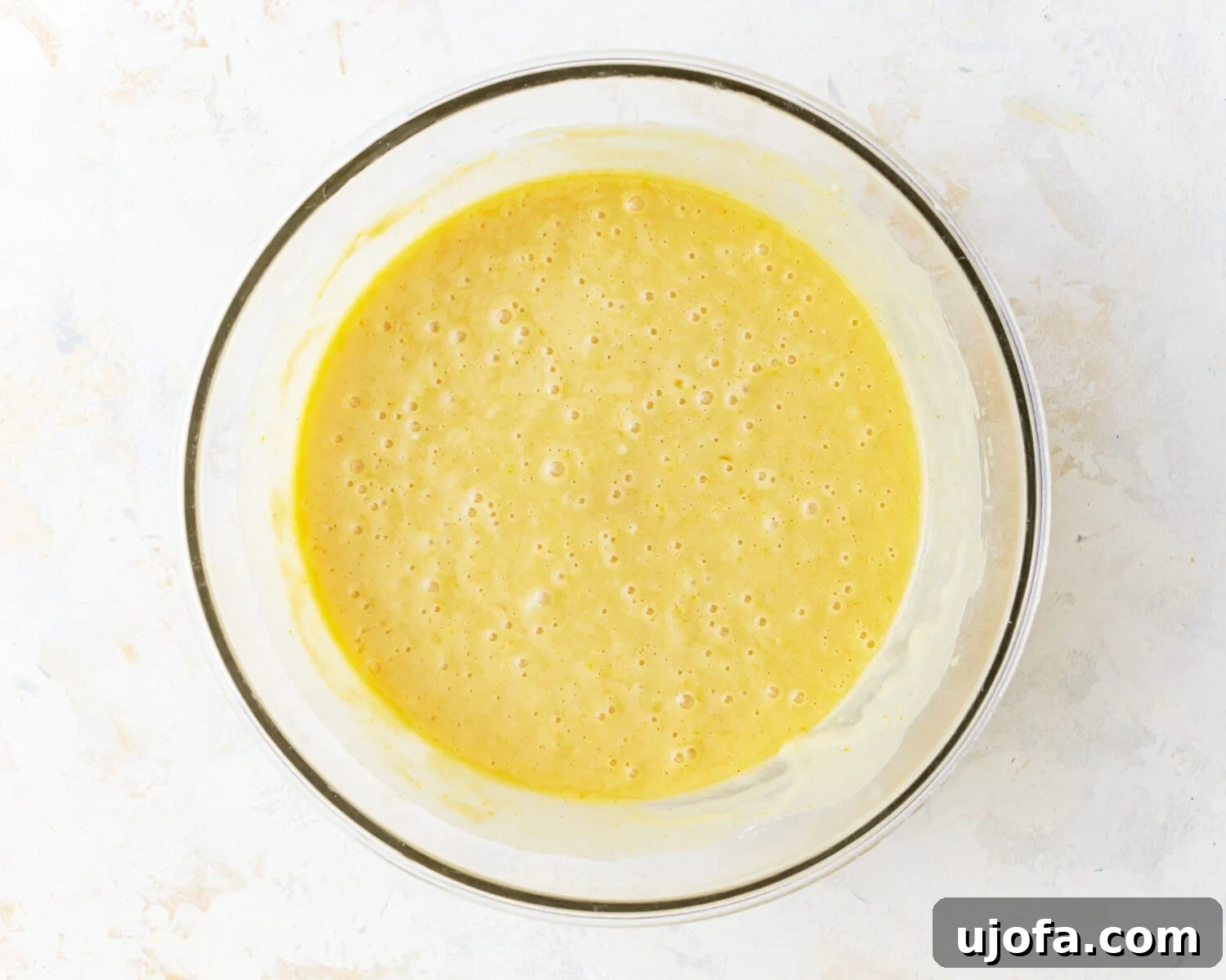 Combined Cake Batter Gluten-free vanilla cake batter in a glass mixing bowl after combining wet and dry ingredients.