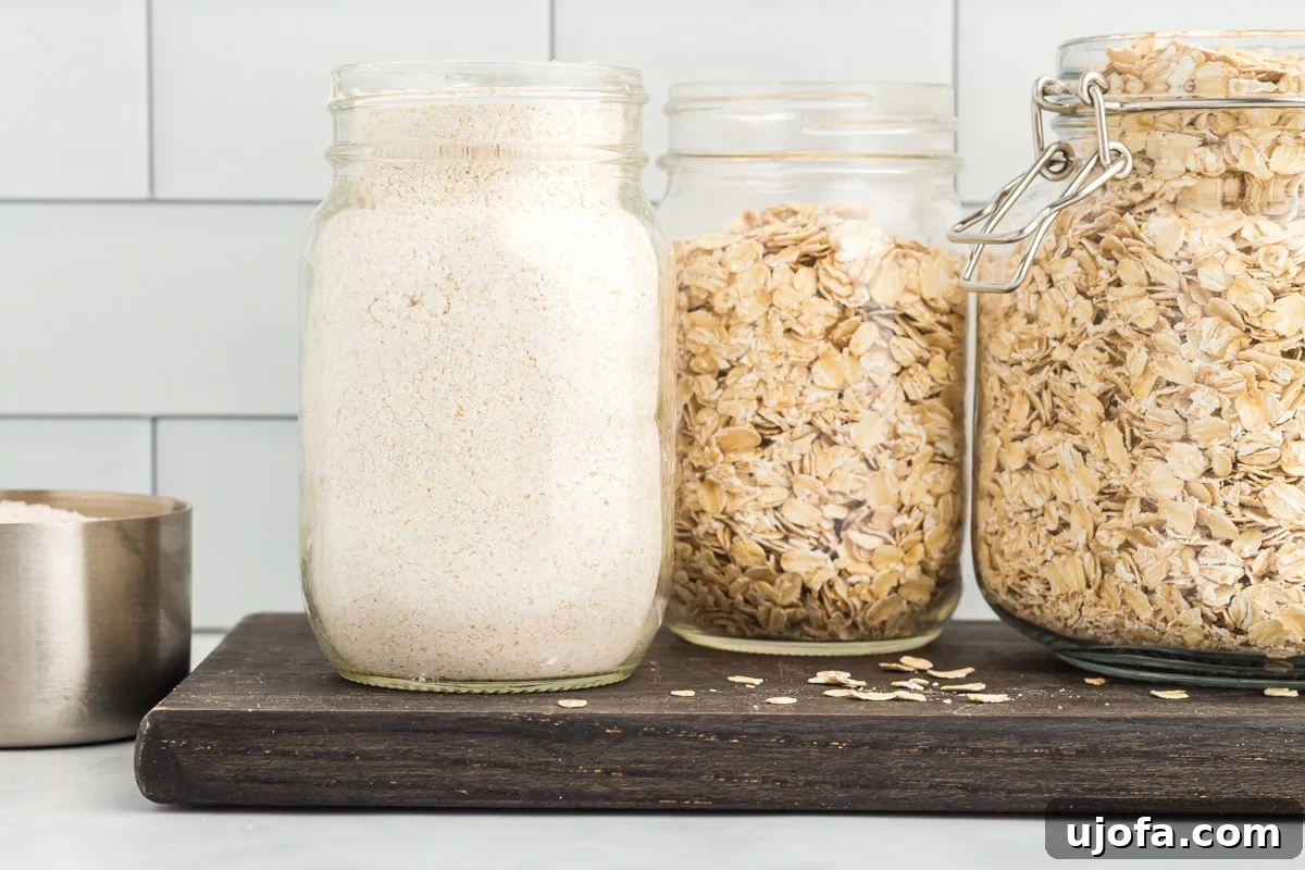 Crafting Homemade Oat Flour 5 side view of oat flour in a glass jar on a wooden cutting board.