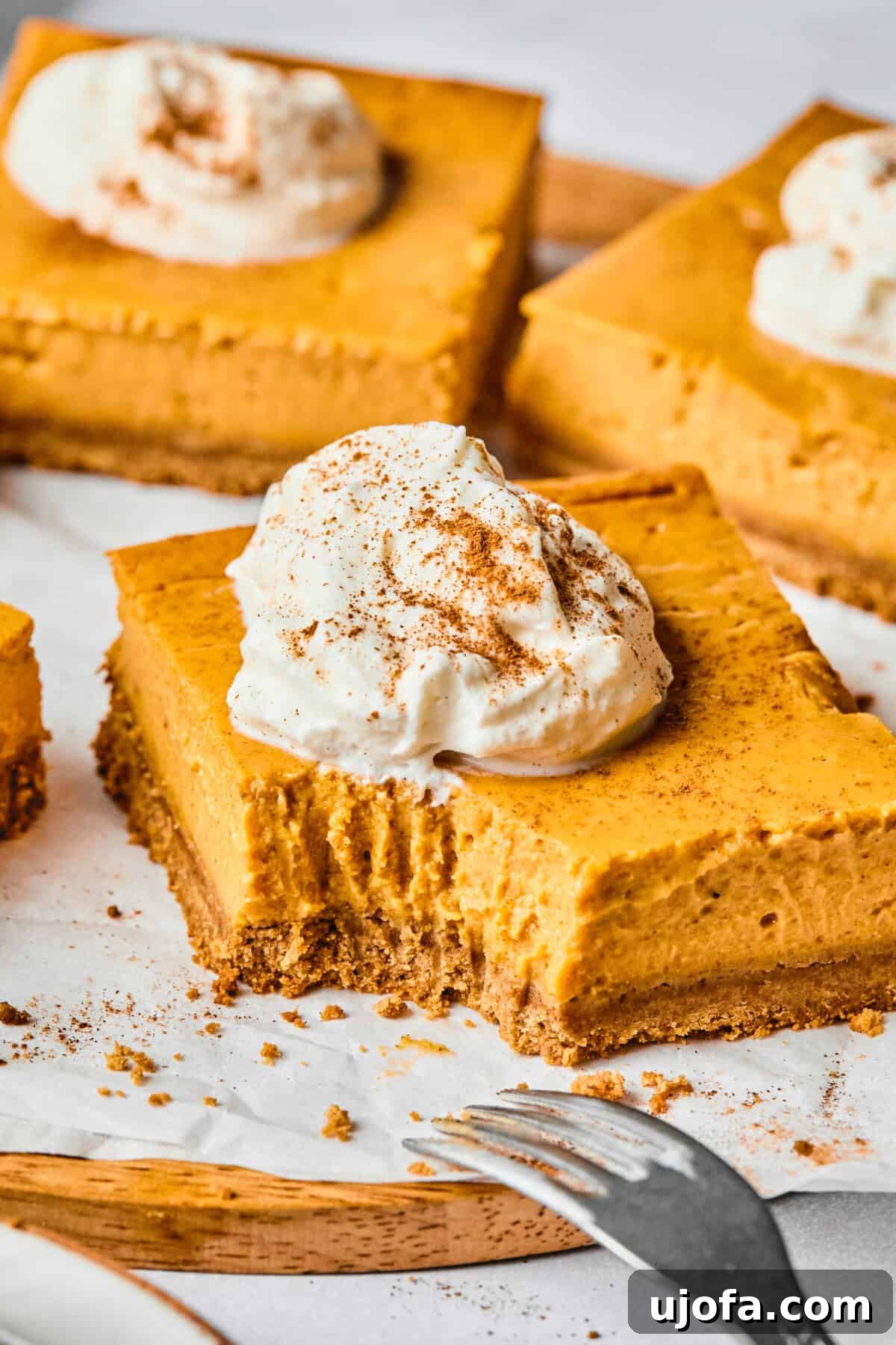 Easy Protein-Packed Pumpkin Cheesecake Bars 10 protein pumpkin pie bars with a bite taken out of one