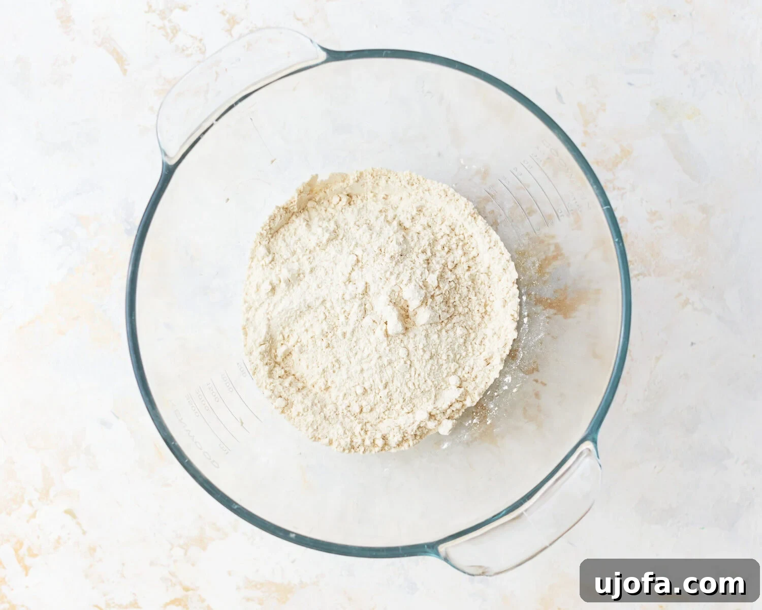 Dry ingredients for gluten-free baguette in a glass mixing bowl.