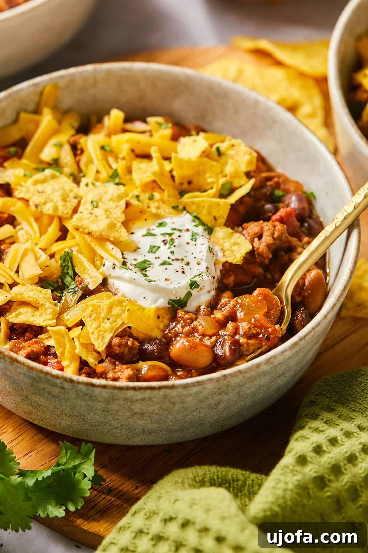 Ultimate Slow Cooker Taco Chili Recipe 11 A spoon lifting a scoop of rich, thick chili from a bowl, highlighting the texture and heartiness of the dish.