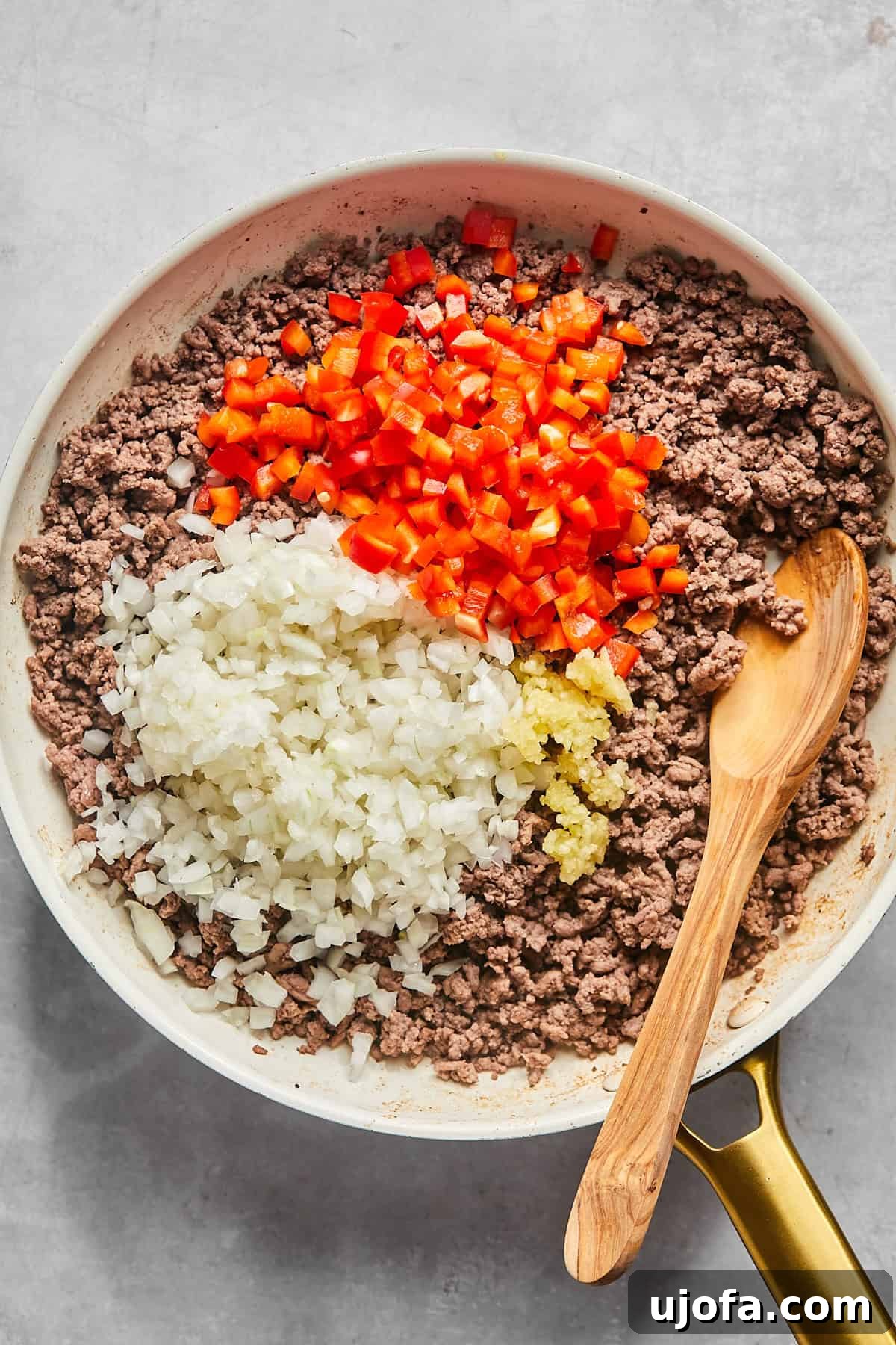 Ultimate Slow Cooker Taco Chili Recipe 5 Diced bell peppers, onions, and minced garlic sautéing with browned ground beef in a skillet, creating an aromatic base for the chili.