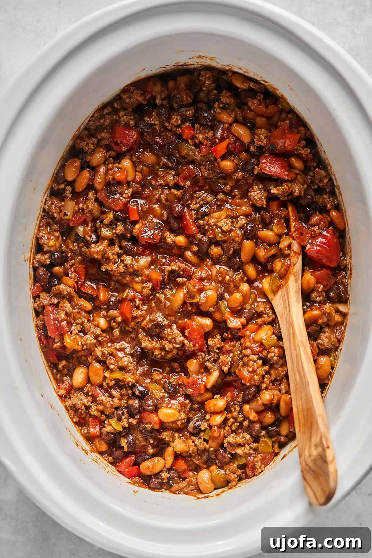 Ultimate Slow Cooker Taco Chili Recipe 8 Uncooked chili mixture in a slow cooker, stirred and ready to be cooked slowly to perfection.