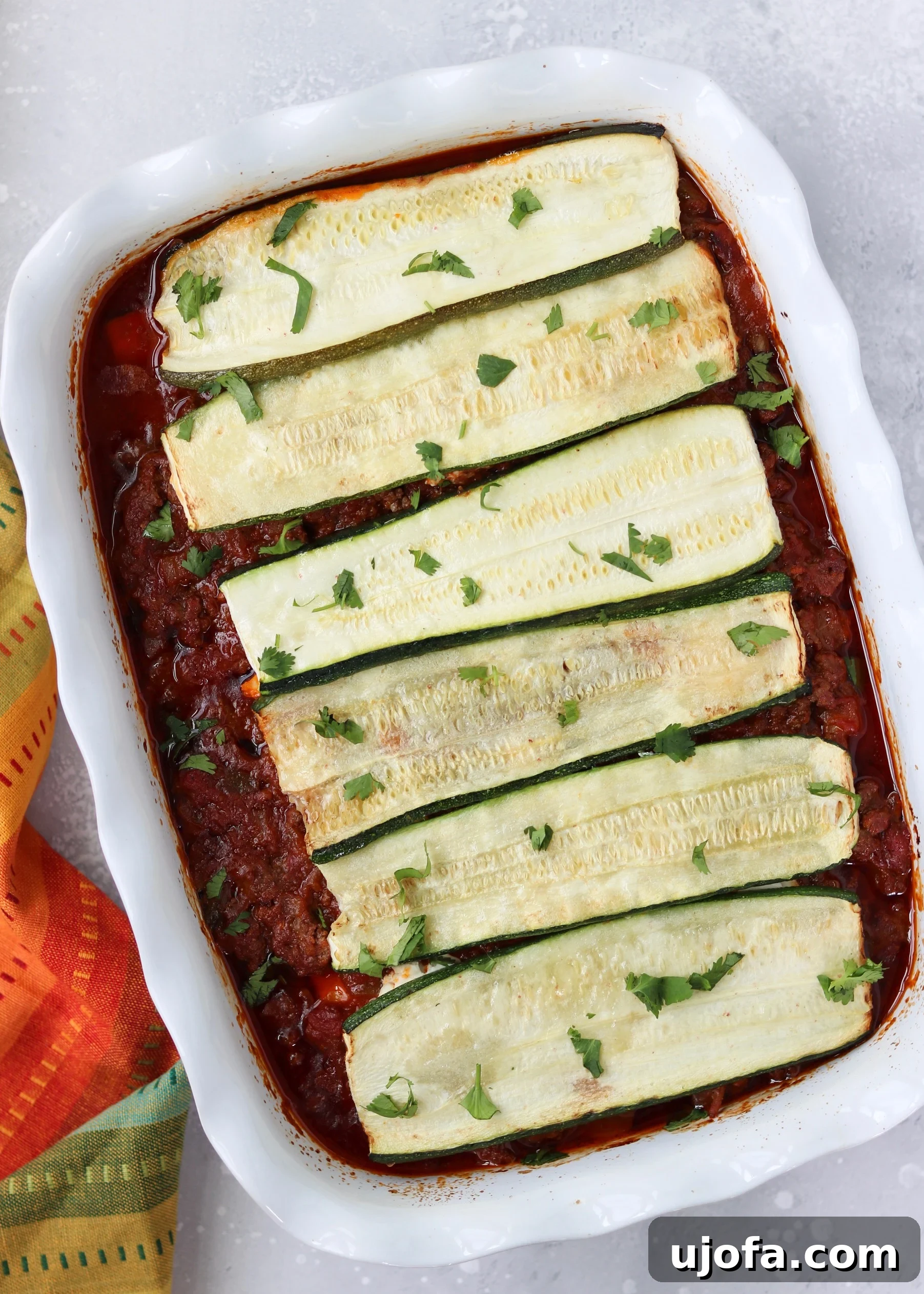 Delicious Paleo Mexican Lasagna freshly baked in a pan, showcasing layers of zucchini, meat sauce, and creamy dairy-free cheese.