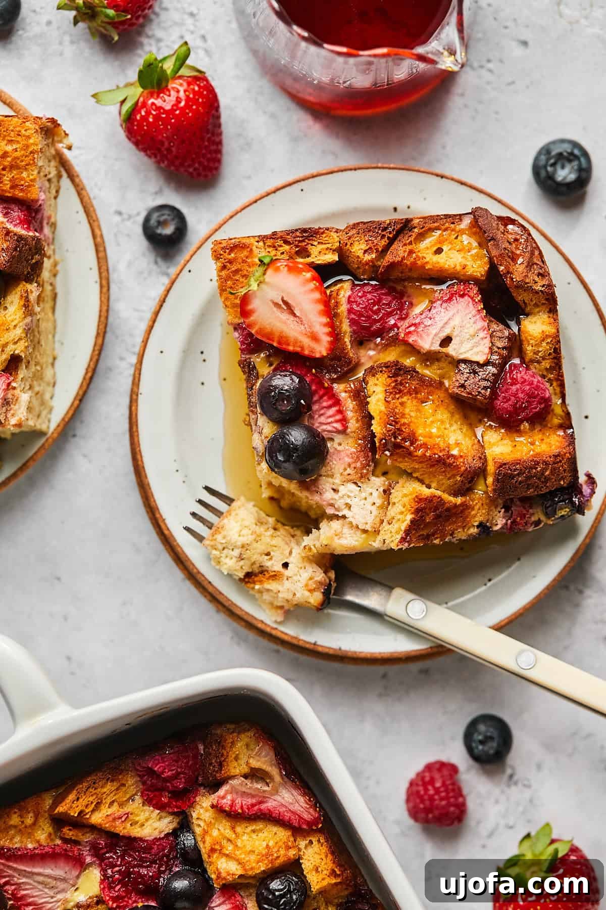 A perfectly portioned square of Protein French Toast Casserole on a white plate, accompanied by a fork, ready to be enjoyed.