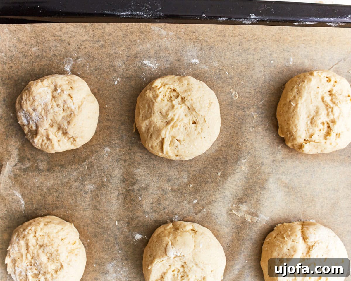 Burger Bliss Without The Gluten 8 Six evenly shaped gluten-free hamburger bun dough balls placed on a parchment-lined baking sheet.