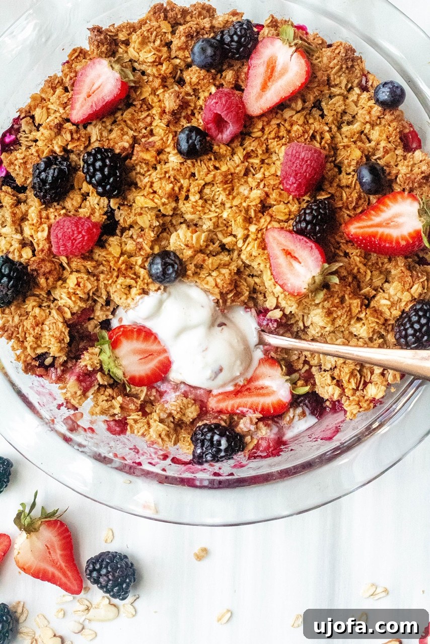 Close-up of a warm Gluten Free Berry Crisp with a scoop taken out.