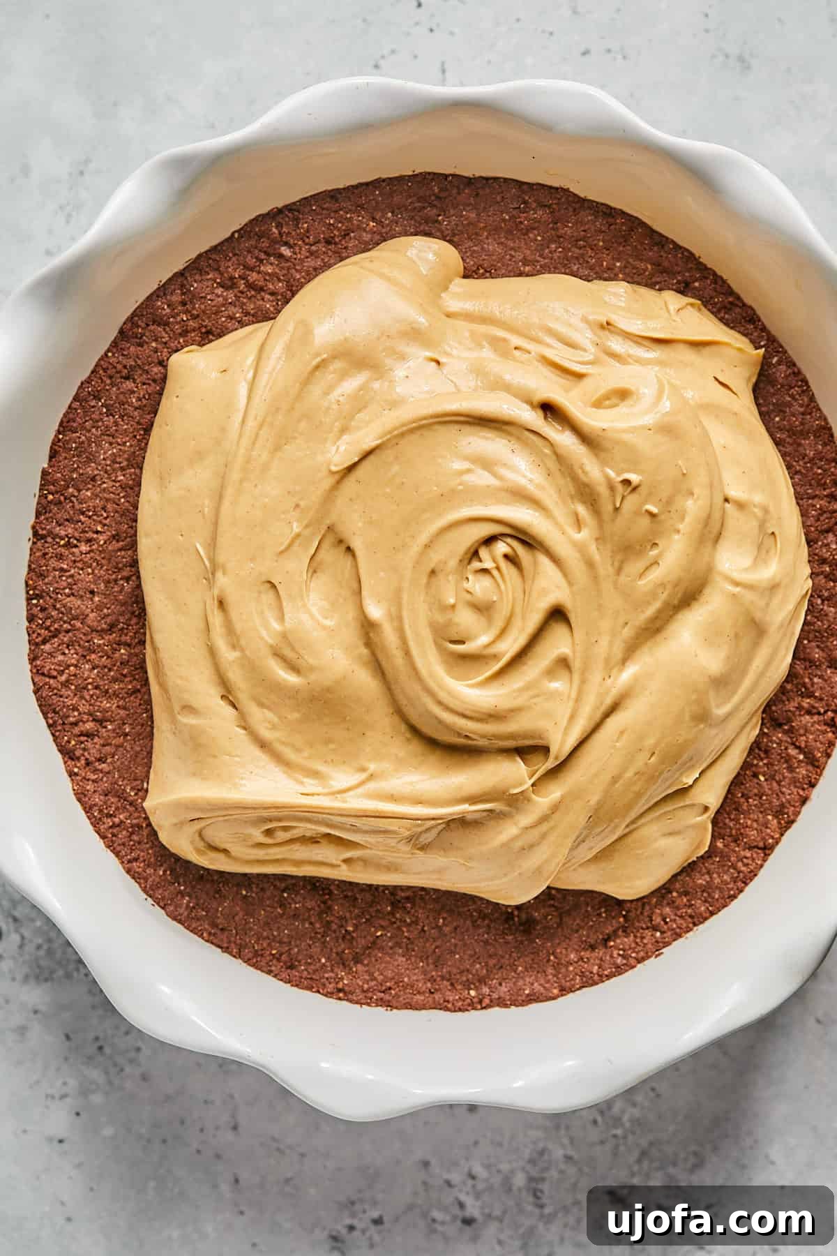 No-Bake Vegan Peanut Butter Bliss 12 The fluffy peanut butter pie filling spread evenly over the chocolate cookie crust in a pie pan.