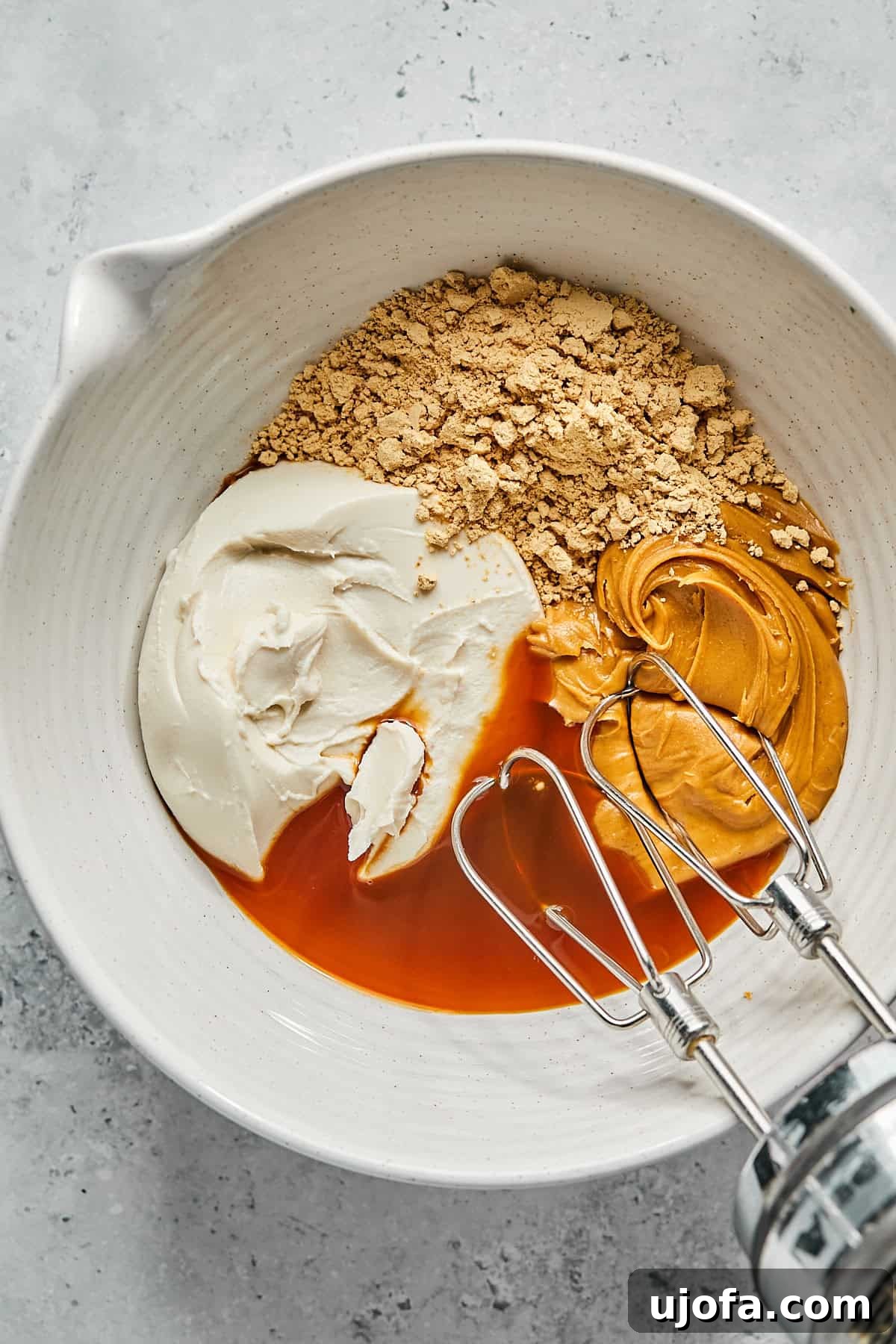 No-Bake Vegan Peanut Butter Bliss 8 Ingredients for the peanut butter pie filling, including peanut butter, cream cheese, powdered peanut butter, maple syrup, and vanilla extract, in a large mixing bowl.