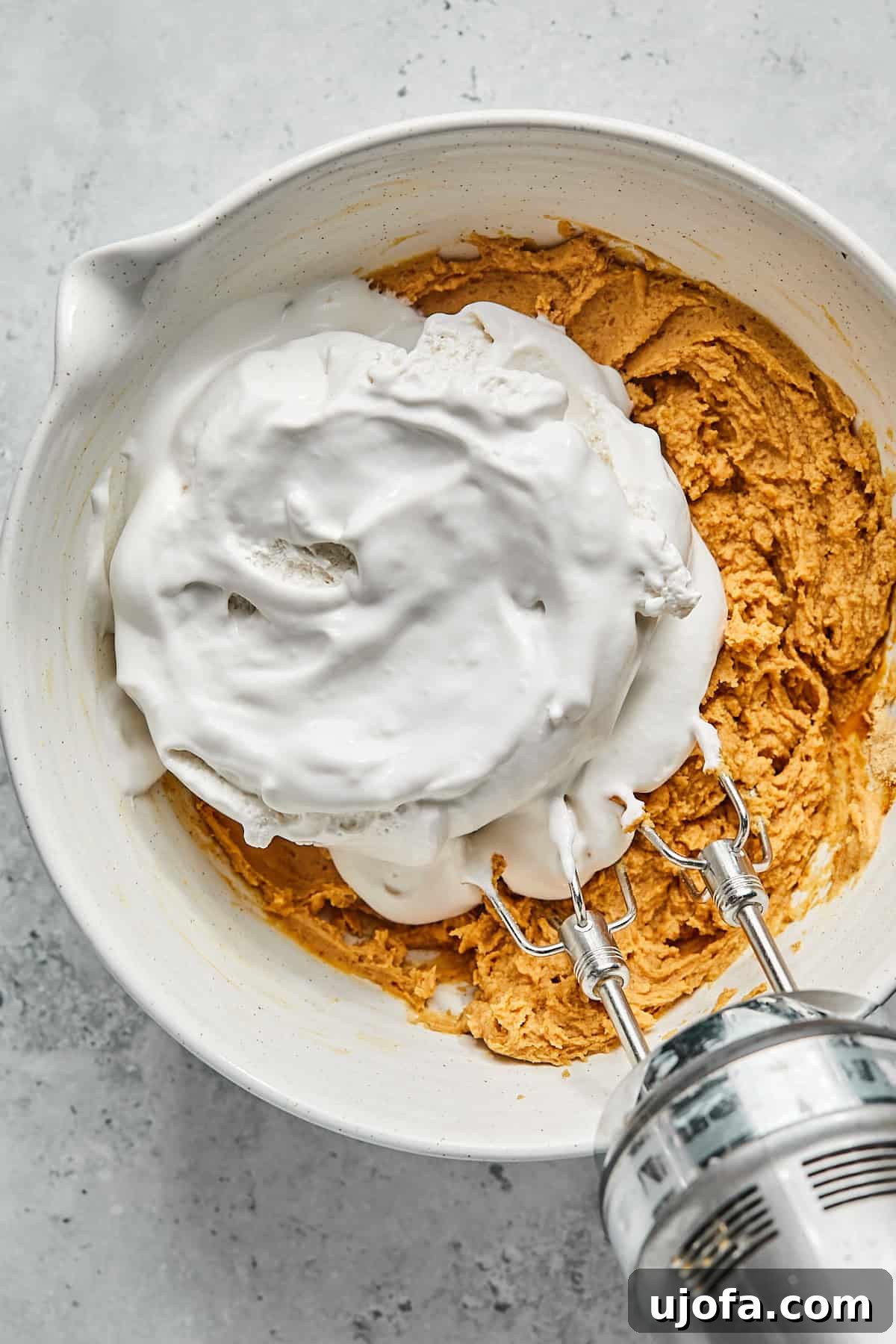 No-Bake Vegan Peanut Butter Bliss 10 Cocowhip dairy-free whipped topping added on top of the mixed peanut butter pie filling ingredients in a bowl.