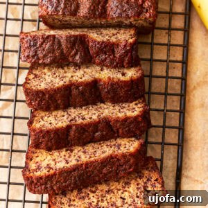 overhead view of a sliced loaf of coconut flour banana bread on a wire rack.
