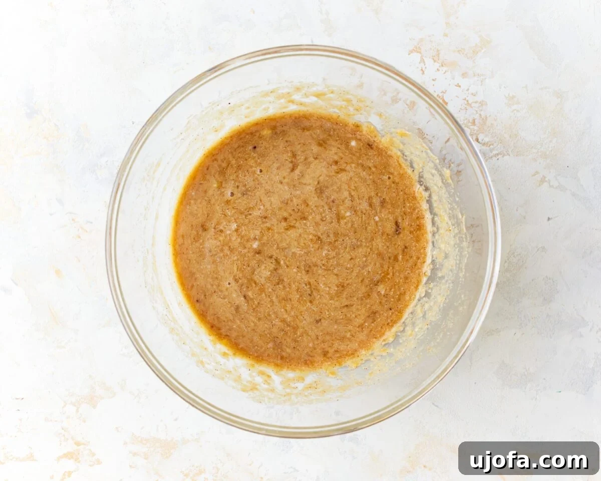 Tropical Coconut Banana Bread 7 coconut flour banana bread batter in a glass bowl resting on a light surface, showing its thick yet smooth consistency.