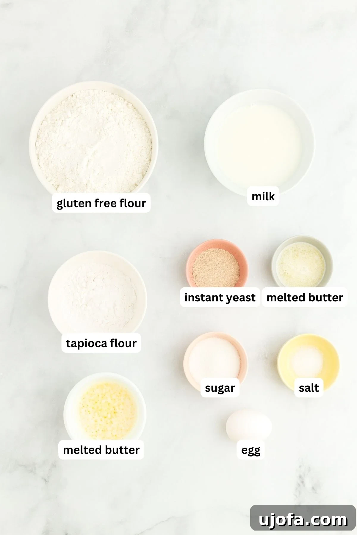 Various ingredients for gluten-free hot dog buns laid out on a white surface.