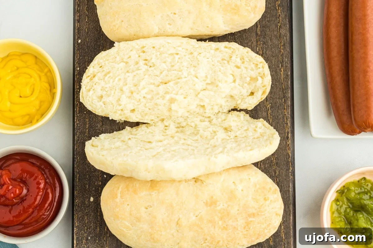 An overhead view of a perfectly sliced homemade gluten-free hot dog bun, ready for filling.