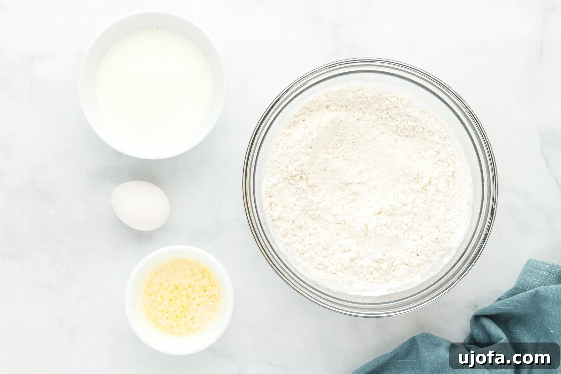 Dry ingredients for gluten-free hot dog buns in a glass mixing bowl, ready to be combined.