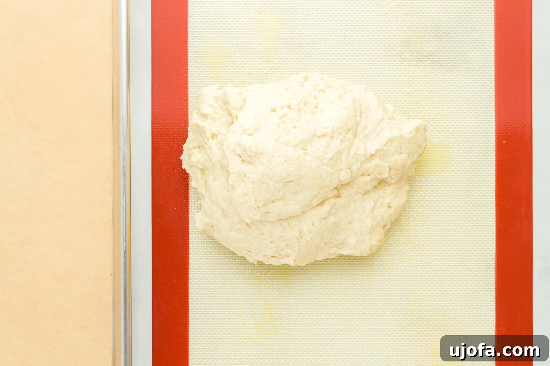 A smooth ball of gluten-free hot dog bun dough on a lightly oiled work surface.
