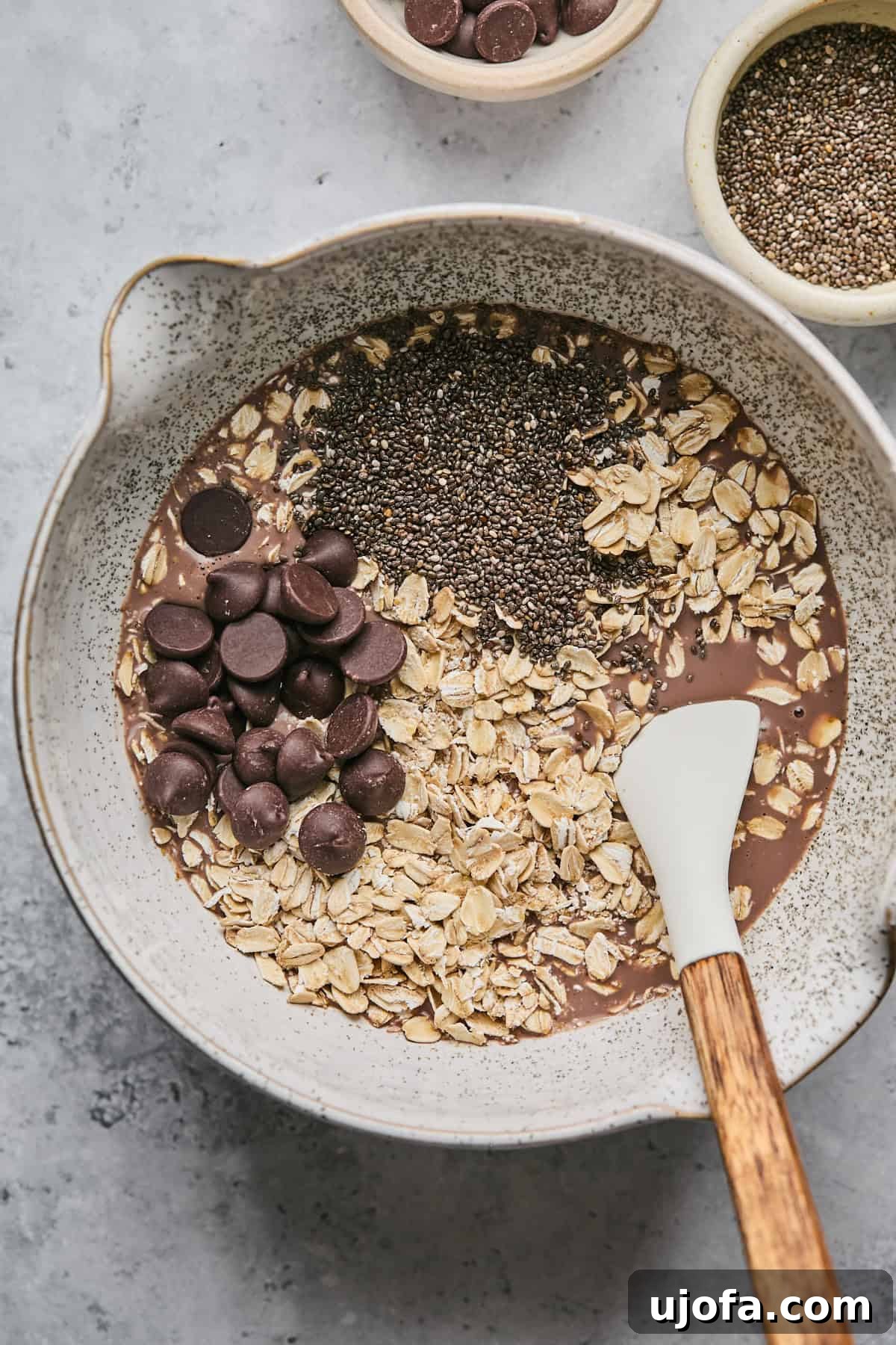 chocolate overnight oats ingredients in a bowl with a spatula