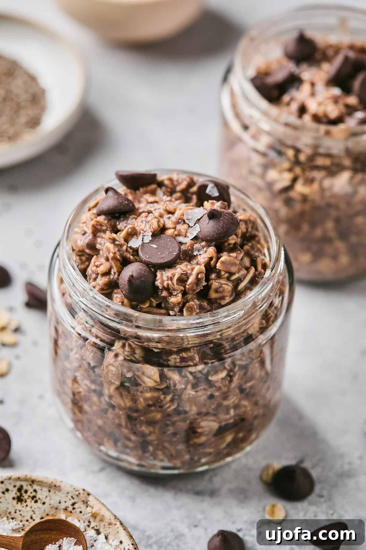 chocolate overnight oats in a glass jar surrounded by chocolate chips