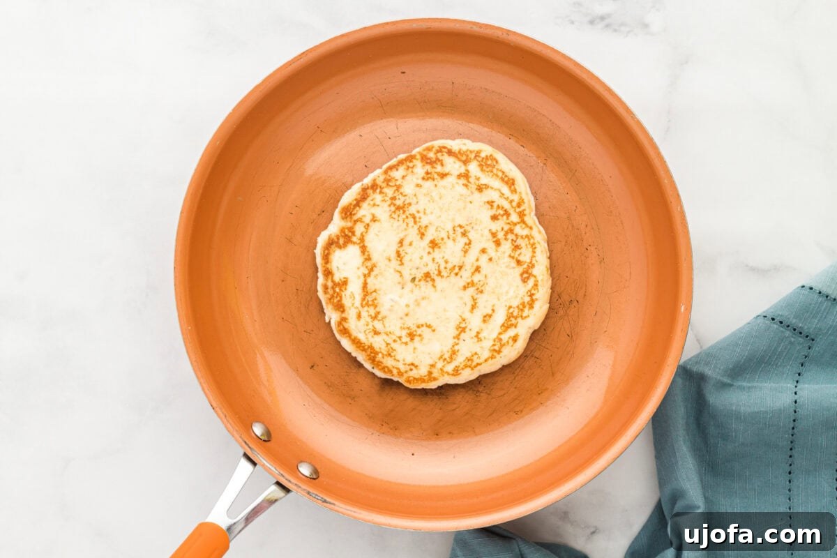 Effortless Gluten-Free Flatbread 12 gluten-free flatbread browning and bubbling in an orange skillet